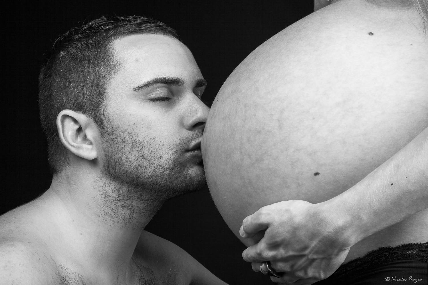 Un baiser sur le ventre de sa femme enceinte