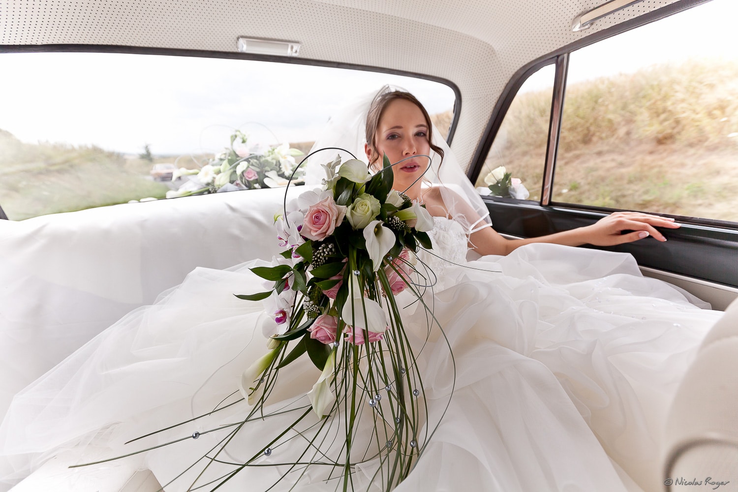 Photographie de la mariée dans la voiture