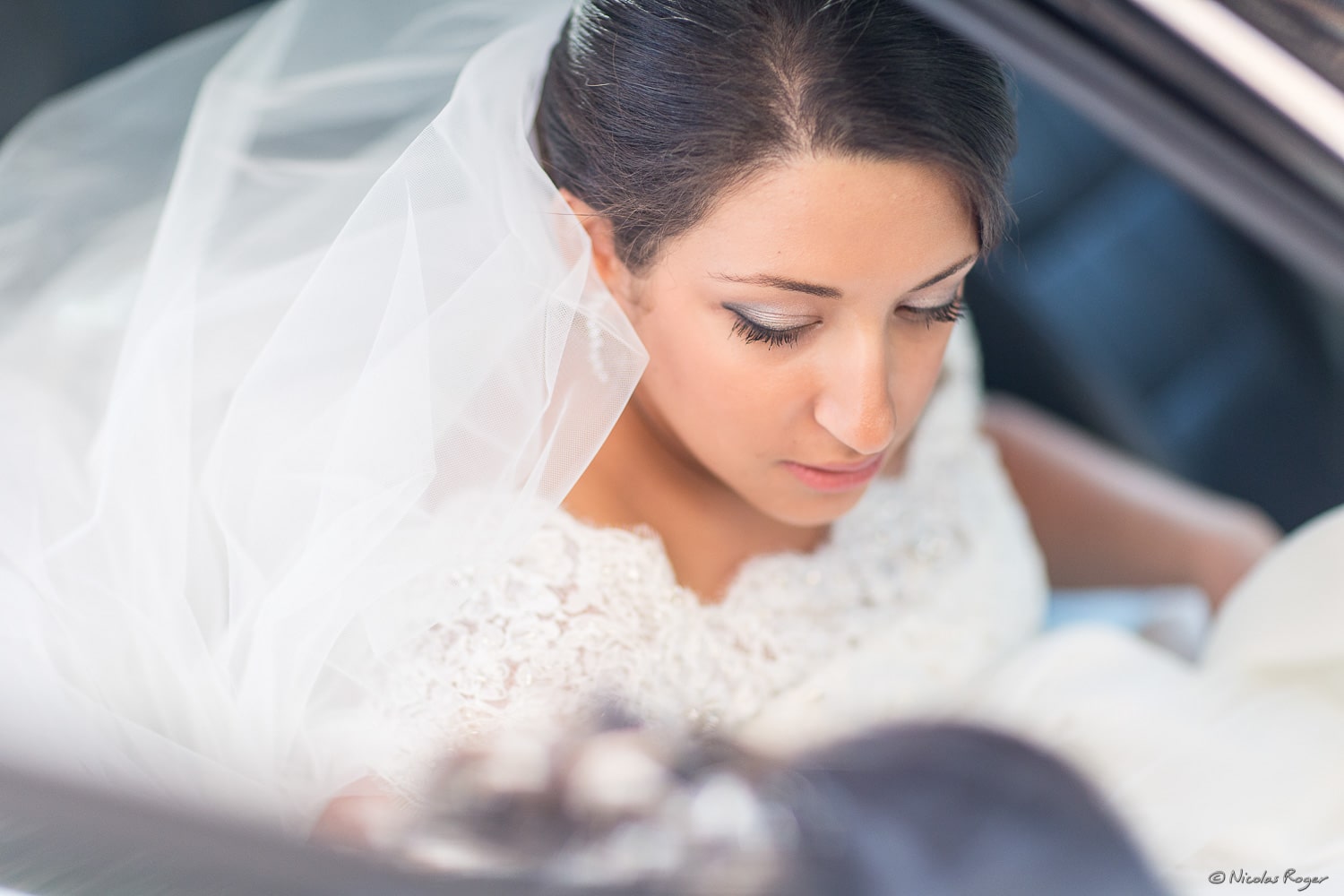 Photographie de la mariée dans la voiture vers le mariage