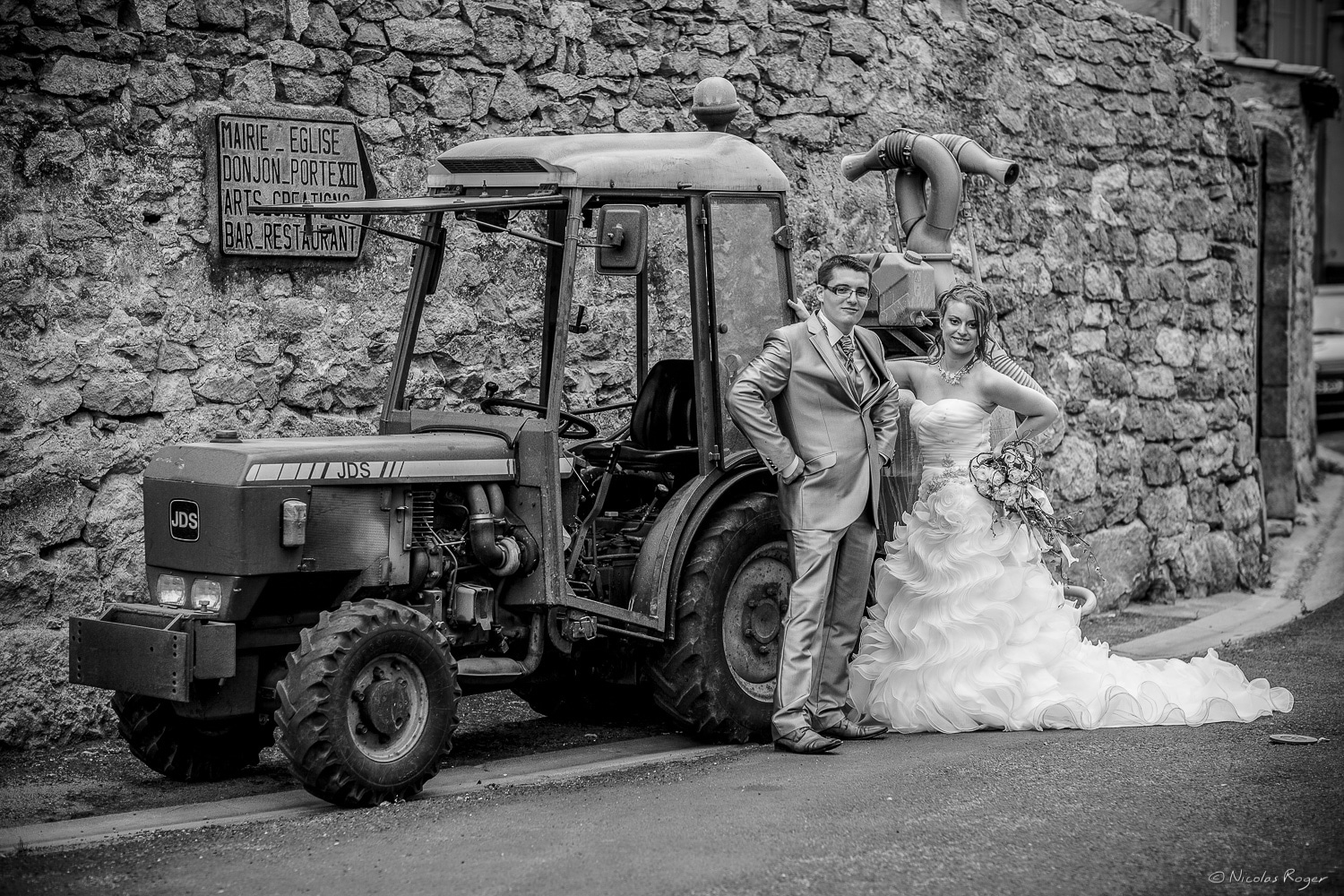 Les mariés posent devant un tracteur