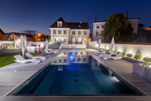 Photographie d'une piscine et maison de nuit