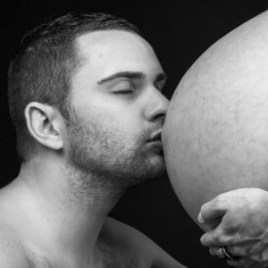 Un baiser sur le ventre de sa femme enceinte