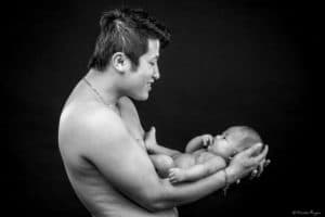 photographie d'un père avec son bébé dans les bras.