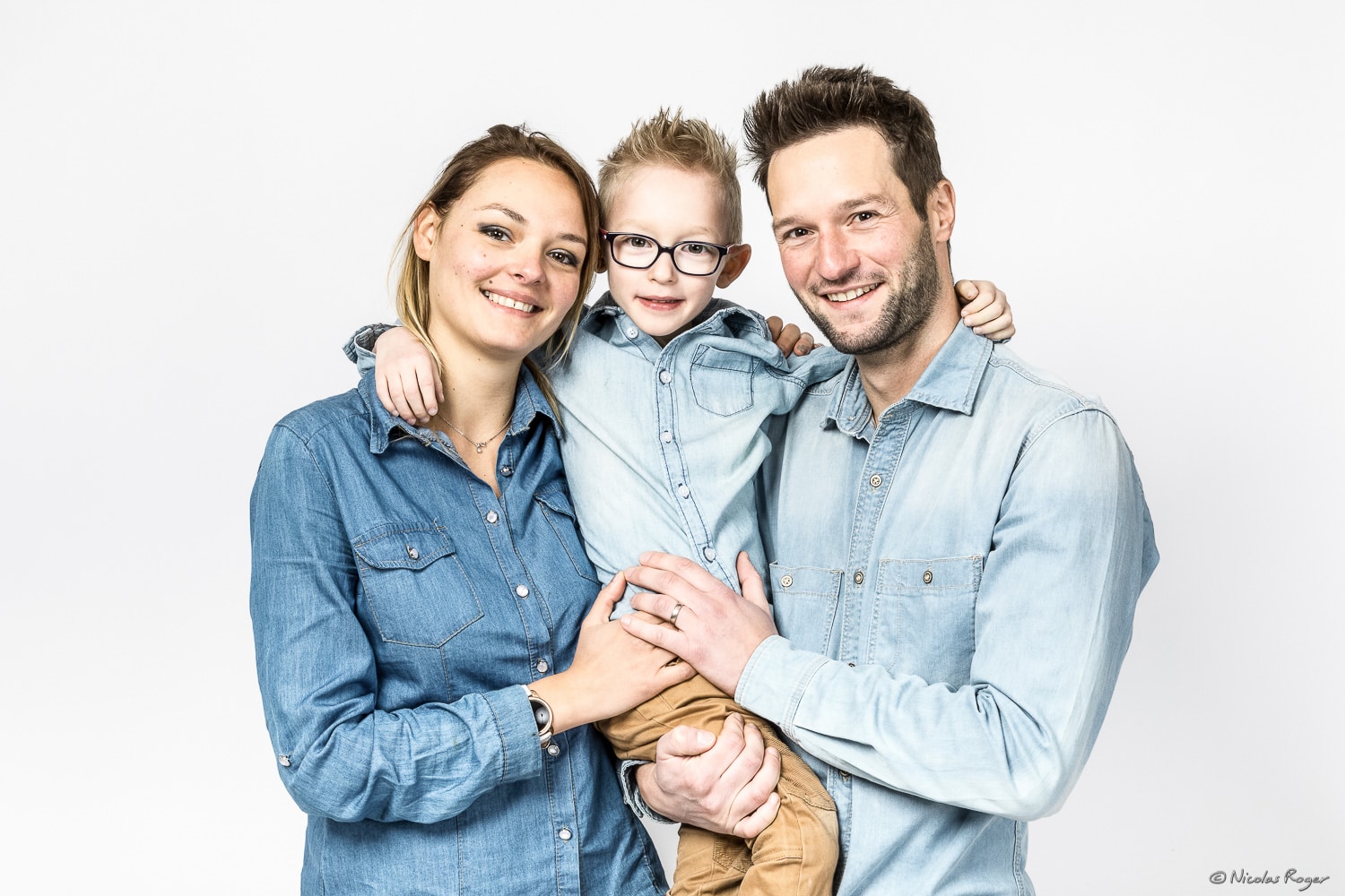 Photographie d&rsquo;une famille avec leur jeune enfant dans les bras.