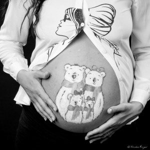 Photographie d'une femme enceinte avec un dessin en belly painting