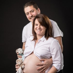 Photographie d'un couple avec la femme enceinte dans un studio photo.