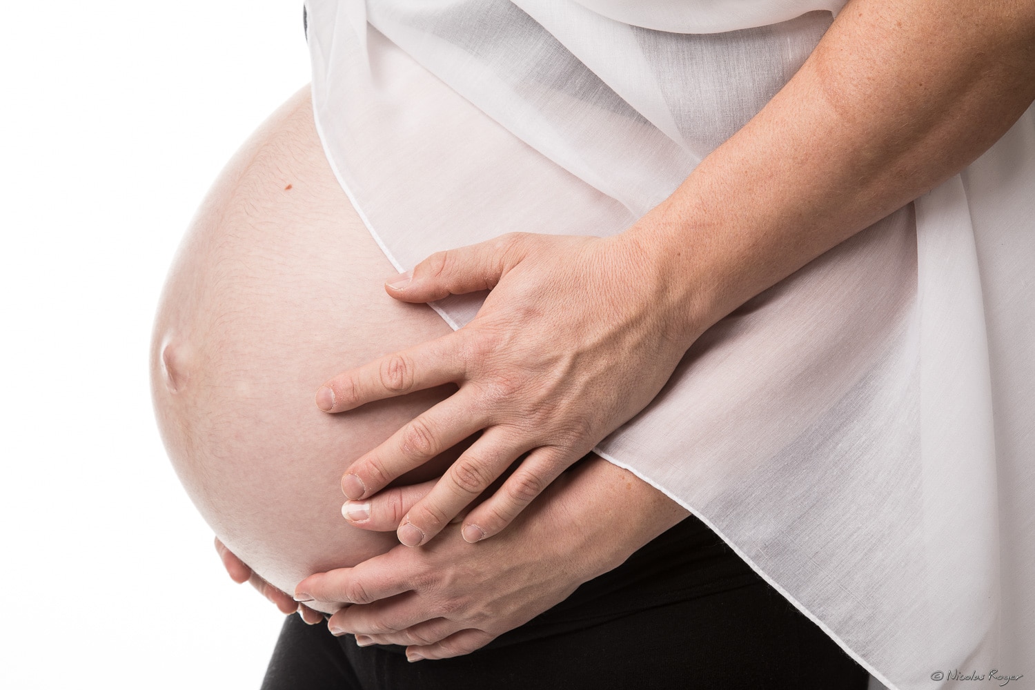 Photographie de grossesse avec les mains des futurs parents