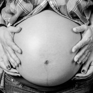 Photographie d'un détail en studio d'une femme enceinte.