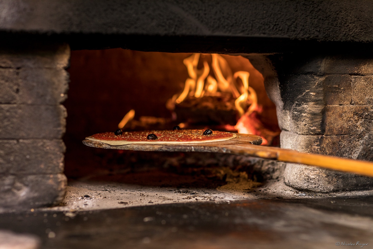 Photographie de la mise au four d&rsquo;une pizza