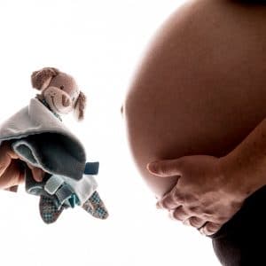 Photographie de grossesse avec le futur doudou de l'enfant