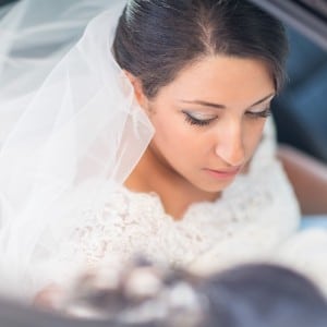 Photographie de la mariée dans la voiture vers le mariage